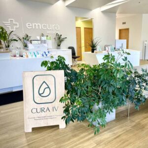 cura iv reception area with sandwich board, big plant, lounge seating and reception desk